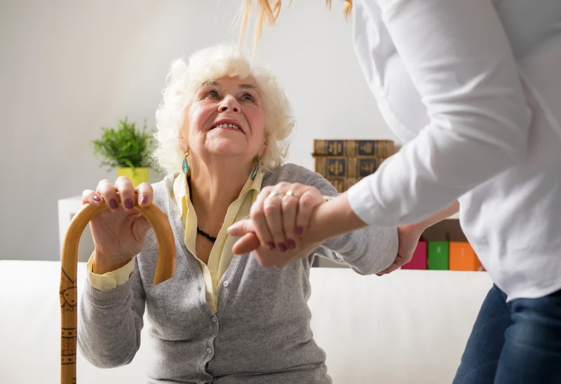 person helping an older person to stand